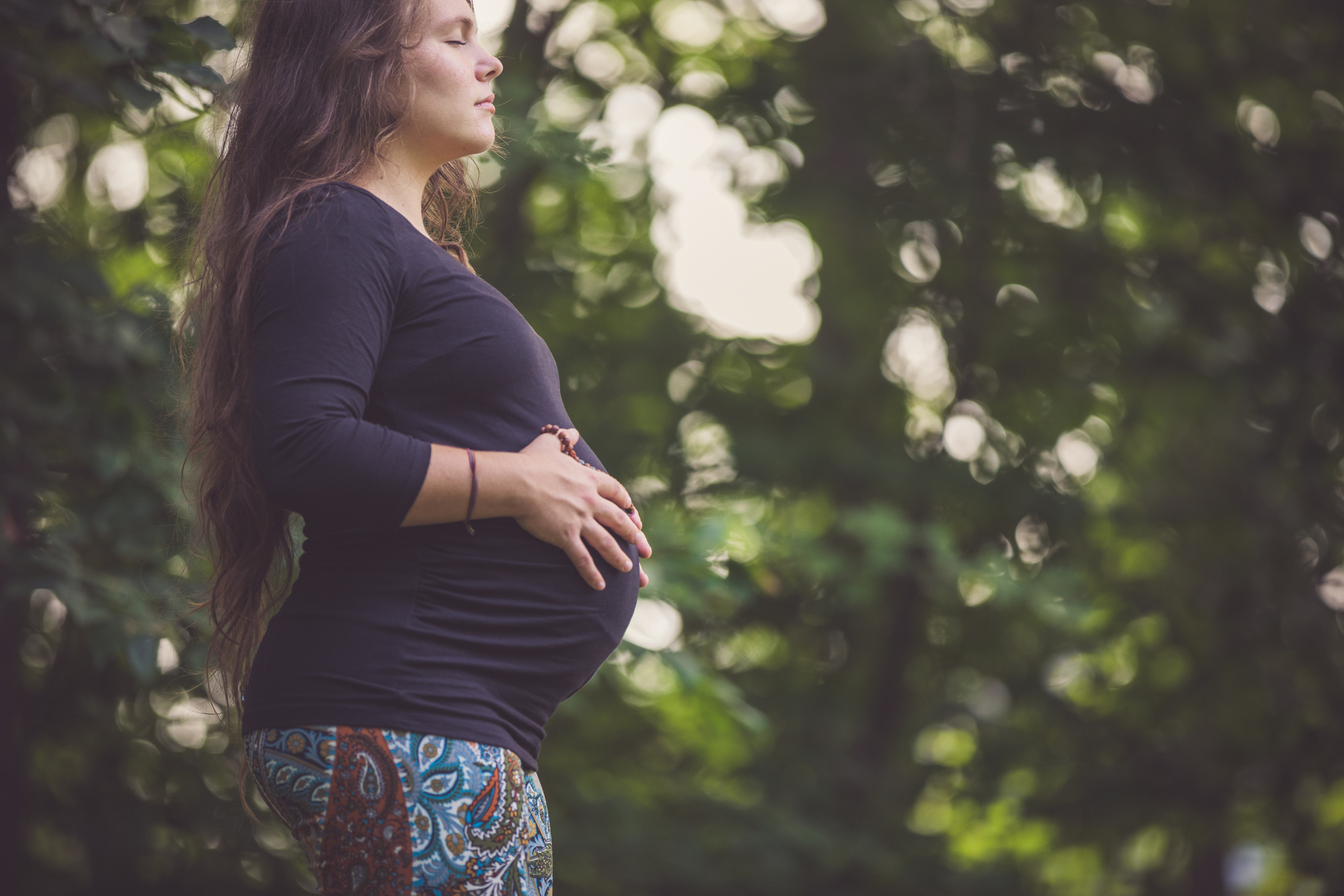 Young Mother To Be Practicing Prenatal Yoga Outdoors